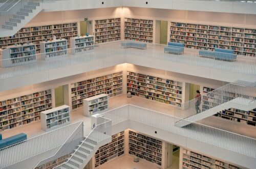Helle, mehrstöckige Bibliothek mit Bücherregalen, Treppen und Sitzplätzen