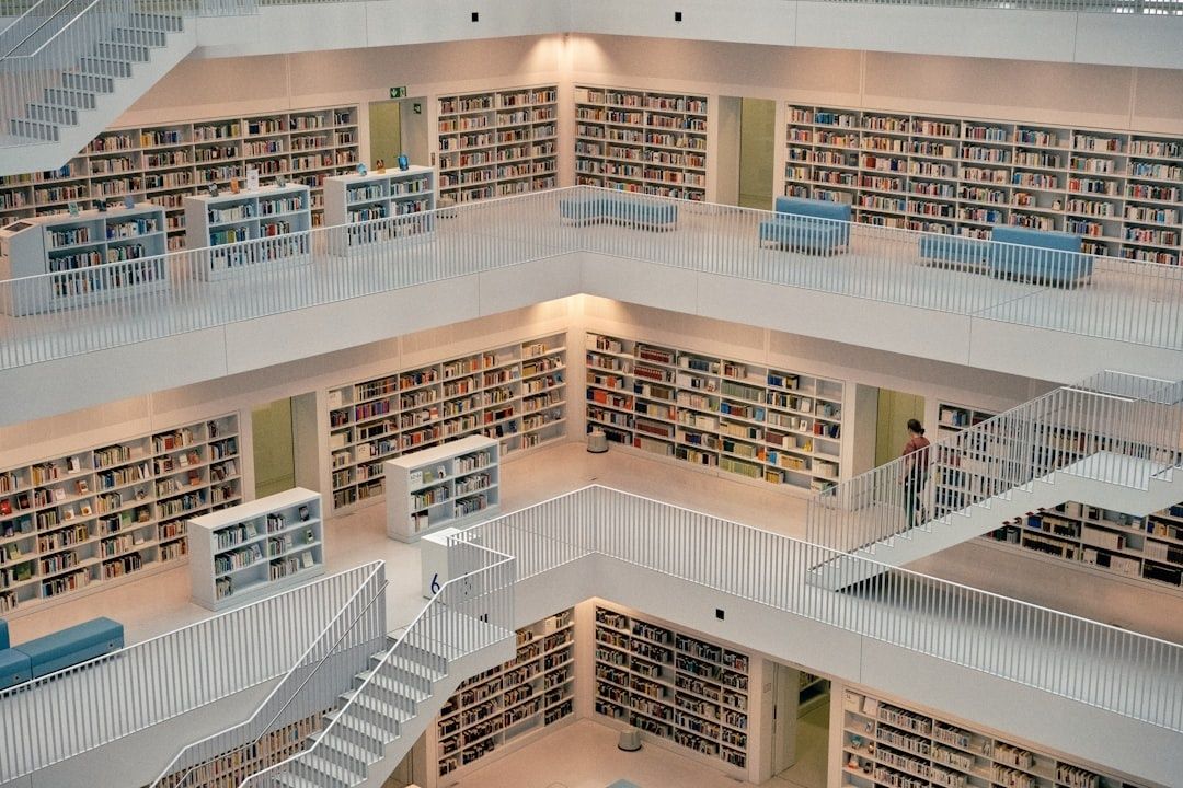 Helle, mehrstöckige Bibliothek mit Bücherregalen, Treppen und Sitzplätzen