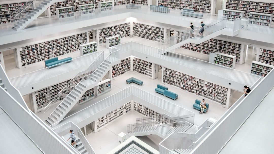 Helle, mehrstöckige Bibliothek mit Bücherregalen, Treppen und Sitzplätzen